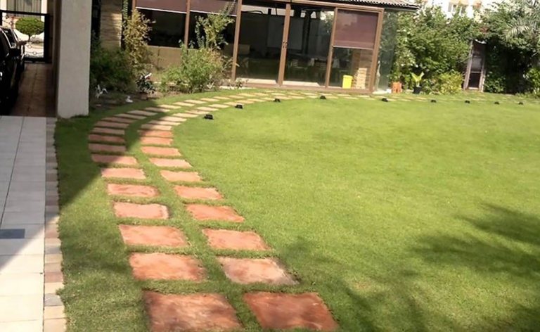 "حديقة منزلية أمام السكن الخاص في الكويت توضح الالتزام بالأسوار النباتية وفق القرار 507 لسنة 2010"